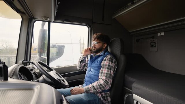 Professional truck driver talking on the phone inside right hand drive car