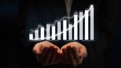 Hands are presenting a rising graph to symbolize growth and success in business and finance. This...