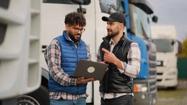 Truck drivers discussing logistics and shipping on a laptop