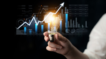 This image illustrates a light bulb symbolizing innovative ideas alongside a growth graph,...