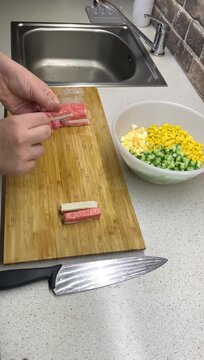 The process of peeling crab sticks, taking them out of the cellophane package in close-up