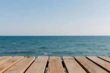 Naklejka premium Wooden planks provide a neutral foreground to a vast ocean view with clear horizon