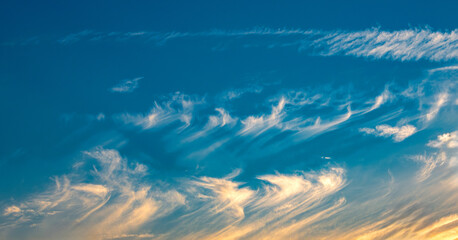 cirrus uncinus clouds in blue sky at sunset