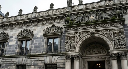 Obraz premium Ornate Stone Facade of a Historic Building with Arched Entrance and Detailed Sculptures