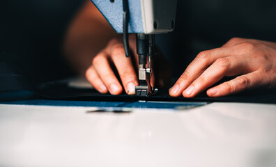 a man at work on a sewing machine. without a face.	
