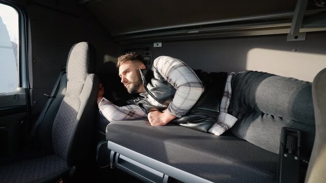 Tired truck driver waking up in a sleeper cab