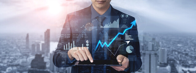 A businessman engaged in data analysis on a tablet, showcasing financial graphs and charts against a vibrant urban backdrop, illustrating modern commerce and innovation. Scalp