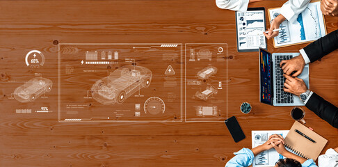 A dynamic business meeting focusing on electric vehicle technology. Participants analyze performance metrics and engage with data on a laptop, displaying insightful charts and statistics. Trope