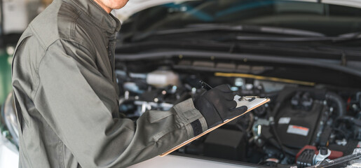 Automobile mechanic checking the engine compartment of a car. Acceptance inspection (vehicle inspection and regular inspection).