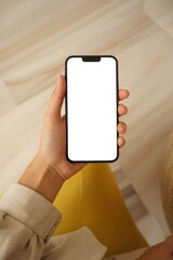 A person holding a smartphone with a blank white screen.