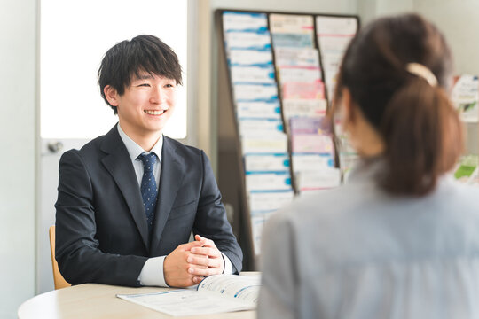 A young Asian businessman negotiating with a female customer (car/insurance)
