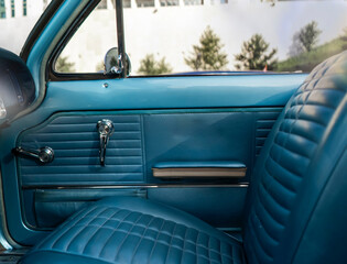 Obraz premium A classic car interior features blue seats and dash with a simple design under natural light