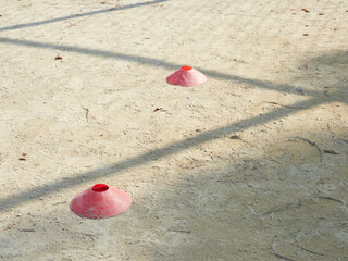 昼の運動場の地面にあるサッカーボール用のボールスタンドの様子