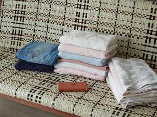 家のリビングのソファーの上にあるバスタオルと携帯電話