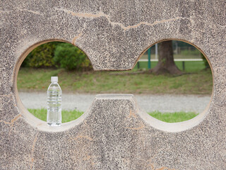 昼の公園の石垣に置いてあるペットボトルの水の様子