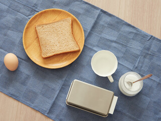 家のリビングのテーブルの上にある食パンとコップの様子