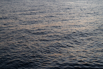 Calm ocean water surface glistening at sunset creating a serene and peaceful scene for travel and meditation concepts