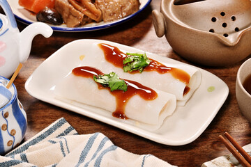 Steamed rice rolls in a dish  on wooden table 