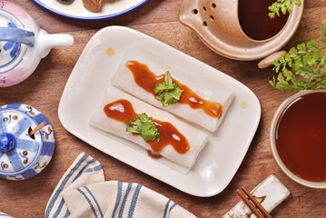 Steamed rice rolls in a dish  on wooden table 