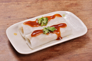 Steamed rice rolls in a dish  on wooden table 