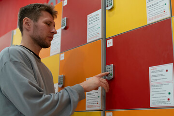 Man stands by storage lockers and enters code on keypad to open his locker