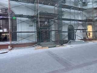 Workers are installing scaffolding around a building in the city as day turns to night