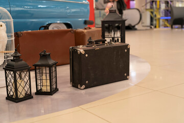 Bags and lanterns are set out on a smooth floor in a busy indoor location with bright colors