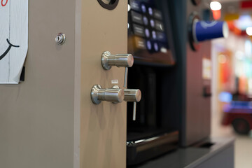 People gather and order drinks while a coffee machine stands ready for use with control knobs