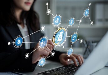 A businesswoman uses her laptop in a modern workspace, analyzing digital network security concepts represented by various icons, showcasing a focus on protection and strategy. Crux