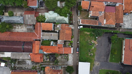 Aerial view of residential buildings with orange rooftops and lush greenery surrounding the structures