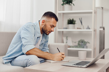 Thoughtful man writing notes in a cozy home office, featuring a minimalist aesthetic and natural light, emphasizing productivity and creativity in 2025 trends.
