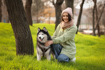 Beautiful young woman with cute husky dog in autumn park