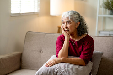 Asian senior woman deep thought alone home expressing sadness depression worry loneliness mental health problems