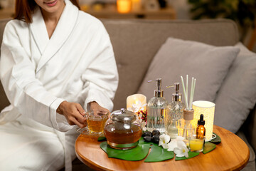 Asian adult woman enjoying hot herbal tea home spa treatment bath robe wellness peaceful atmosphere luxury selfcare