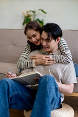 Asian adult couple planning future together happy embrace cozy home sharing ideas notebook writing intimate connection relaxed indoor lifestyle
