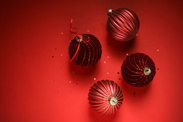 Christmas balls and confetti on red background, closeup