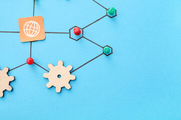 Connected pins with thread, wooden gears and Internet symbol on blue background. Link concept