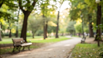 Blurred park pathway with empty benches under trees, offering a serene and peaceful atmosphere for relaxation