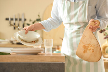 Young woman with many dirty dishes on table at home, closeup