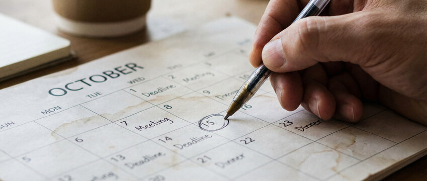 Hand marking date on october calendar scheduling meeting and planning appointment - Powered by Adobe