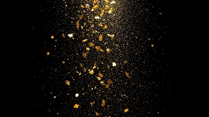 Luxury background with falling golden leaf flakes and glittering particles suspended in the air against a solid black backdrop.