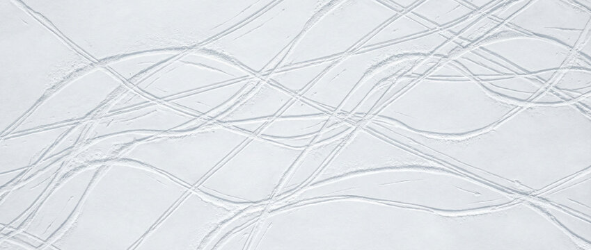 Aerial view of untouched snow with ski tracks on slope in winter season