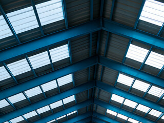 Industrial Metal Roof with Skylights and Support Beams in Blue Tones - Modern Architecture Detail Featuring Geometric Patterns and Natural Lighting