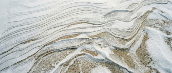 Sand and snow textures with wavy lines pattern abstract background in cold winter