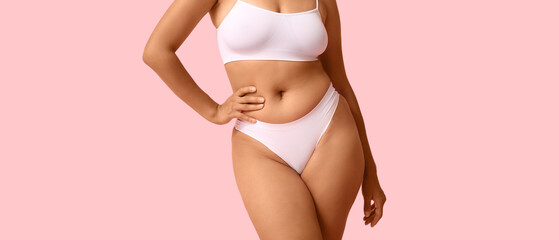 Beautiful young African-American body positive woman on pink background, closeup