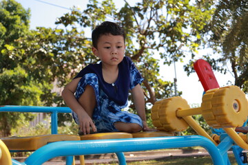 Portrait of a children in a park, A 3-year-old boy is happily walking in the park, wearing an Asian-style blue and white shirt.