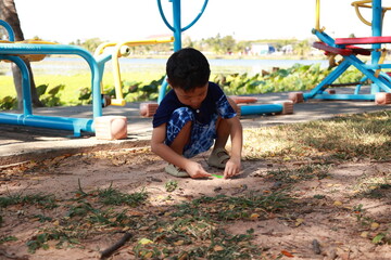 Portrait of a children in a park, A 3-year-old boy is happily walking in the park, wearing an Asian-style blue and white shirt.