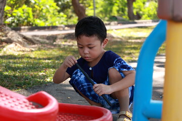 Portrait of a children in a park, A 3-year-old boy is happily walking in the park, wearing an Asian-style blue and white shirt.