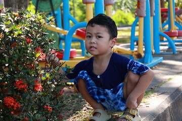 Portrait of a children in a park, A 3-year-old boy is happily walking in the park, wearing an Asian-style blue and white shirt.