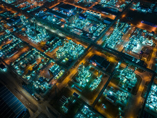 Aerial Night View of Glowing Industrial Complex with Pipelines